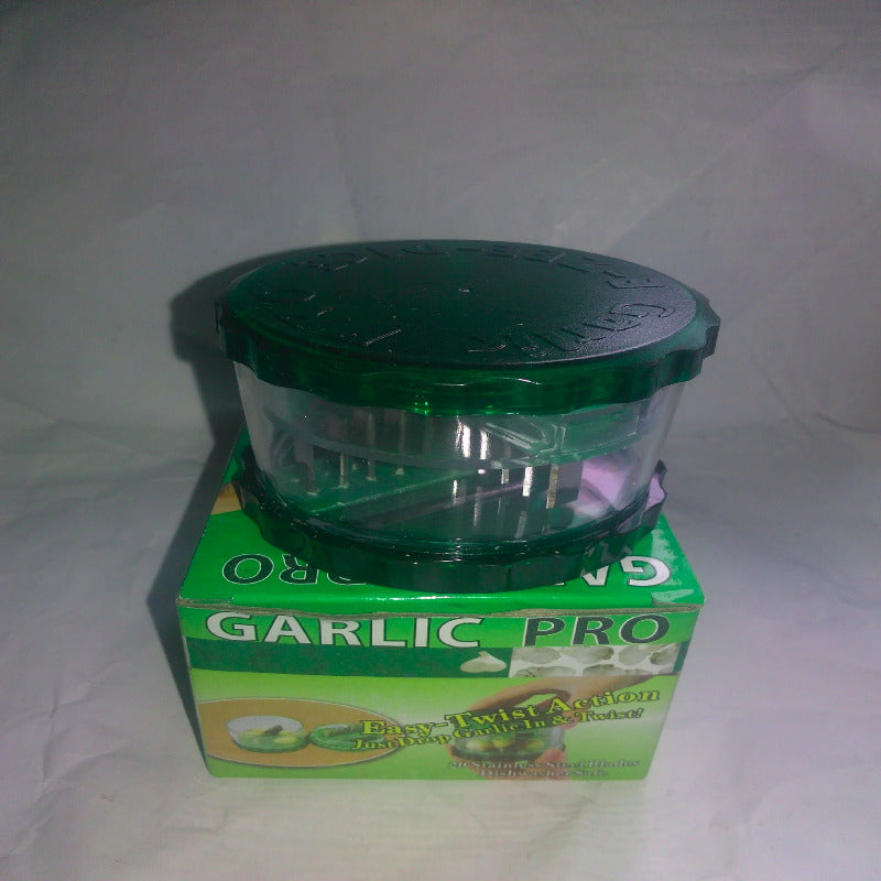 Green garlic press with packaging on a white background
