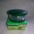 Green garlic press with packaging on a white background