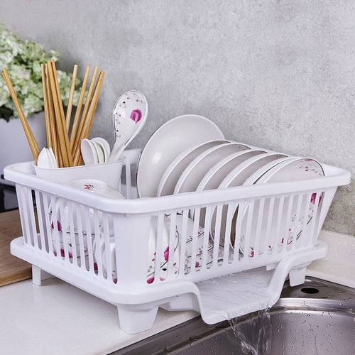 White dish rack with cutlery and plates on a kitchen counter