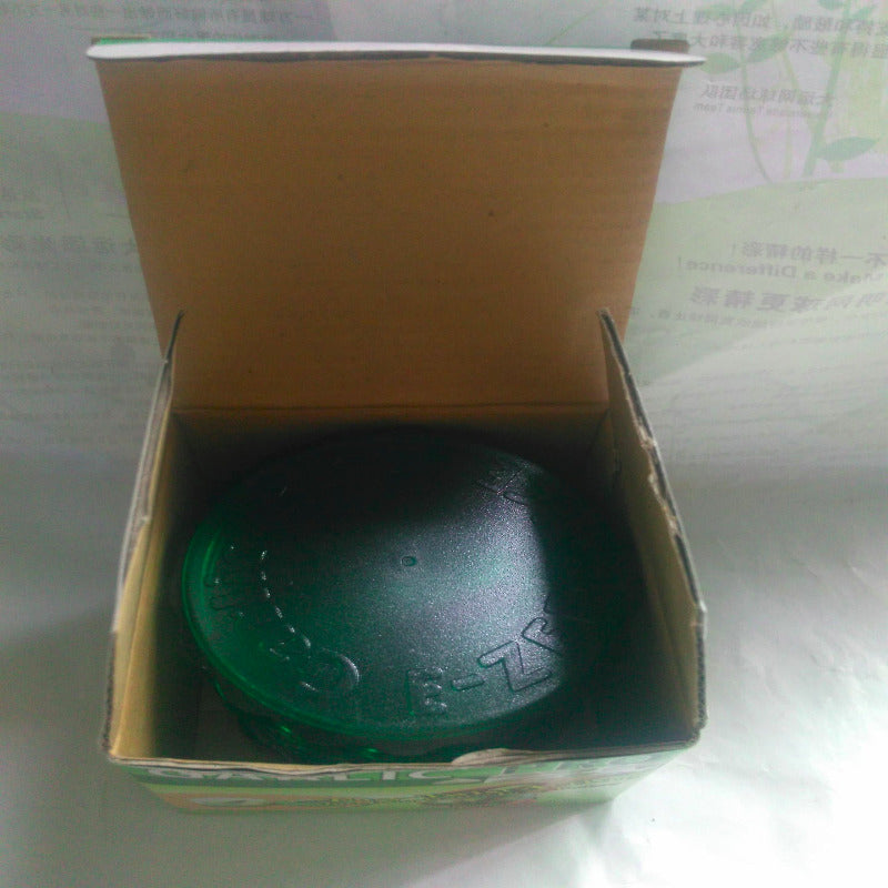 Green ball with a brand logo inside an open cardboard box on a white surface.