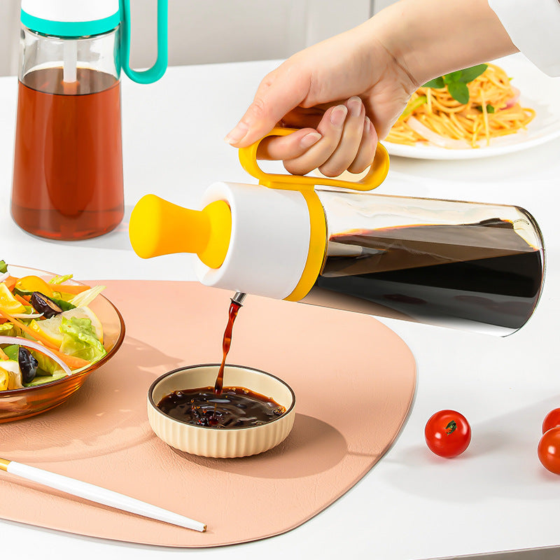 Glass bottle with yellow cap being used to pour dark liquid into a small bowl on a table with food.