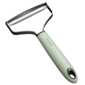 Green vegetable peeler with metal blade on a white background