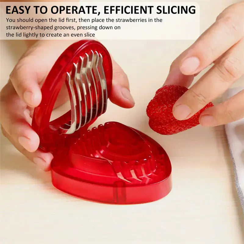 Red strawberry slicer with hands using it to slice a strawberry on a beige background