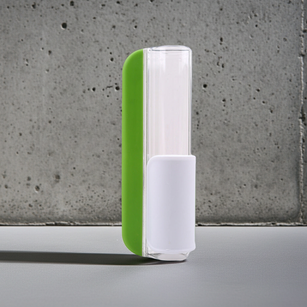 A modern cylindrical cosmetic container with a translucent clear body, a bright green side panel, and a white base, standing on a gray surface against a textured gray concrete wall.