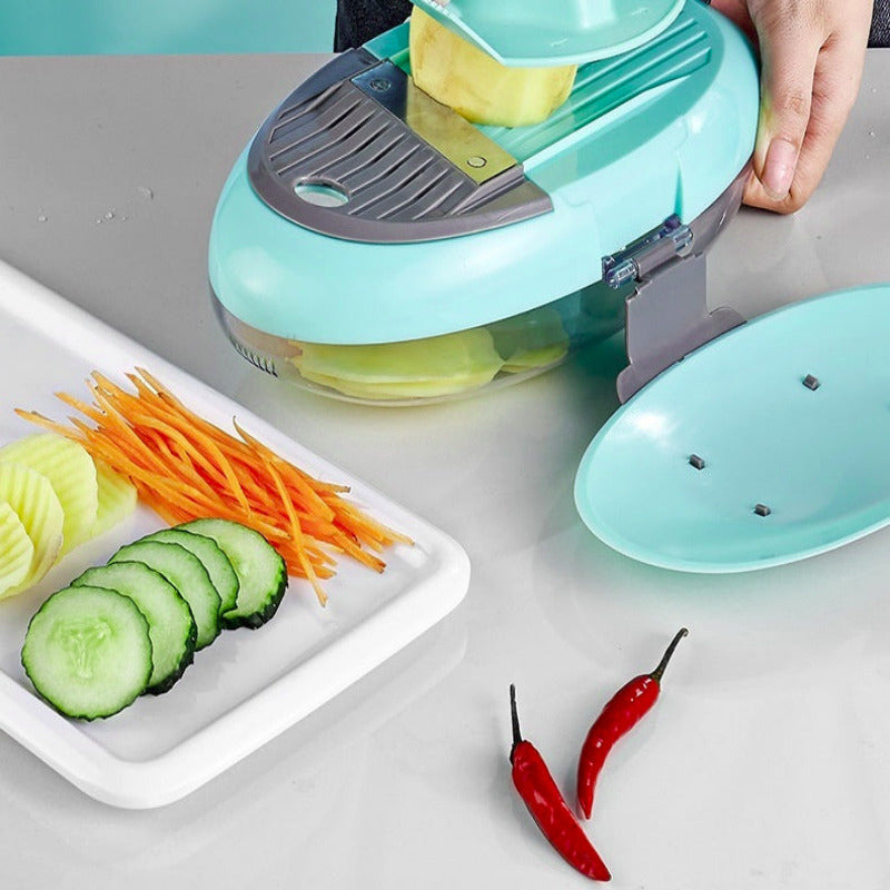 Vegetable slicer cutting vegetables on a gray surface with sliced cucumbers and carrots on a plate.