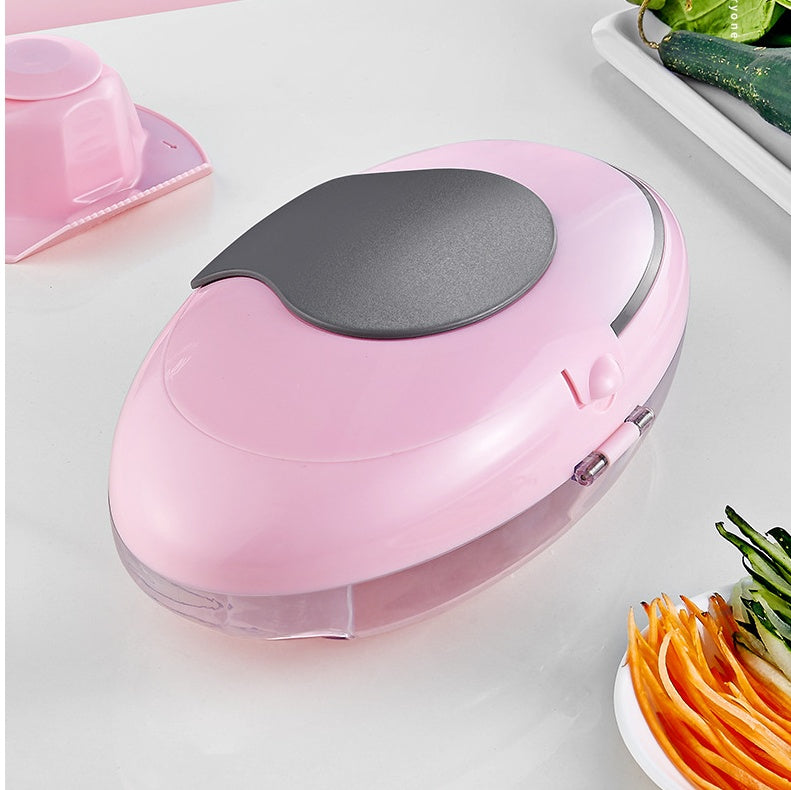 Pink and gray spiralizer on a white surface with vegetables around