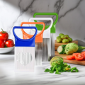 Three vegetable slicers with blue, orange, and green handles are arranged on a marble countertop with fresh vegetables, including tomatoes, Brussels sprouts, and a head of cabbage.