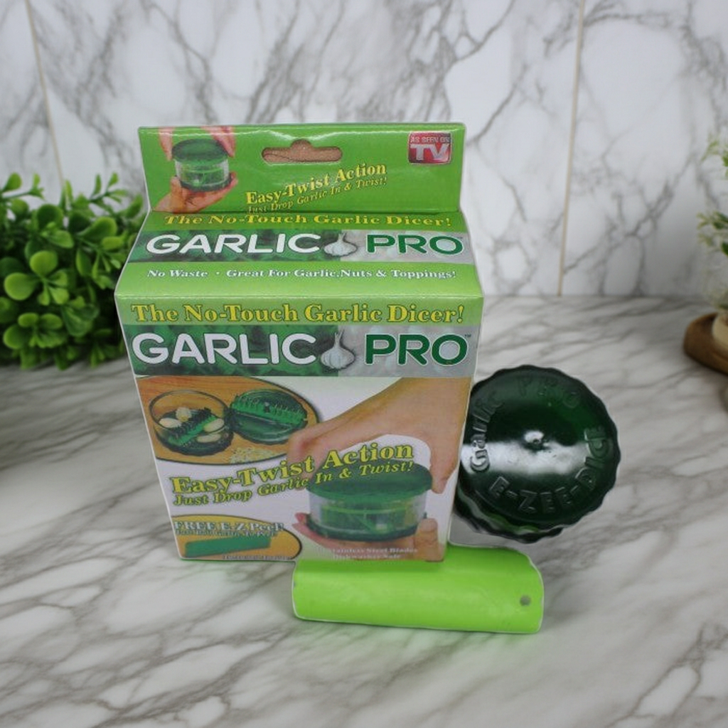 Garlic Pro garlic dicer packaging box shown next to a green garlic dicer tool on a marble surface with a marble wall background.